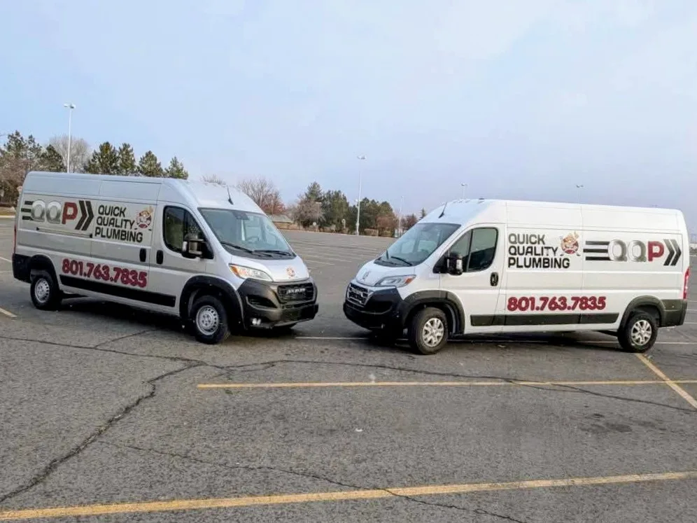 Two Quick Quality Plumbing service vans with company branding